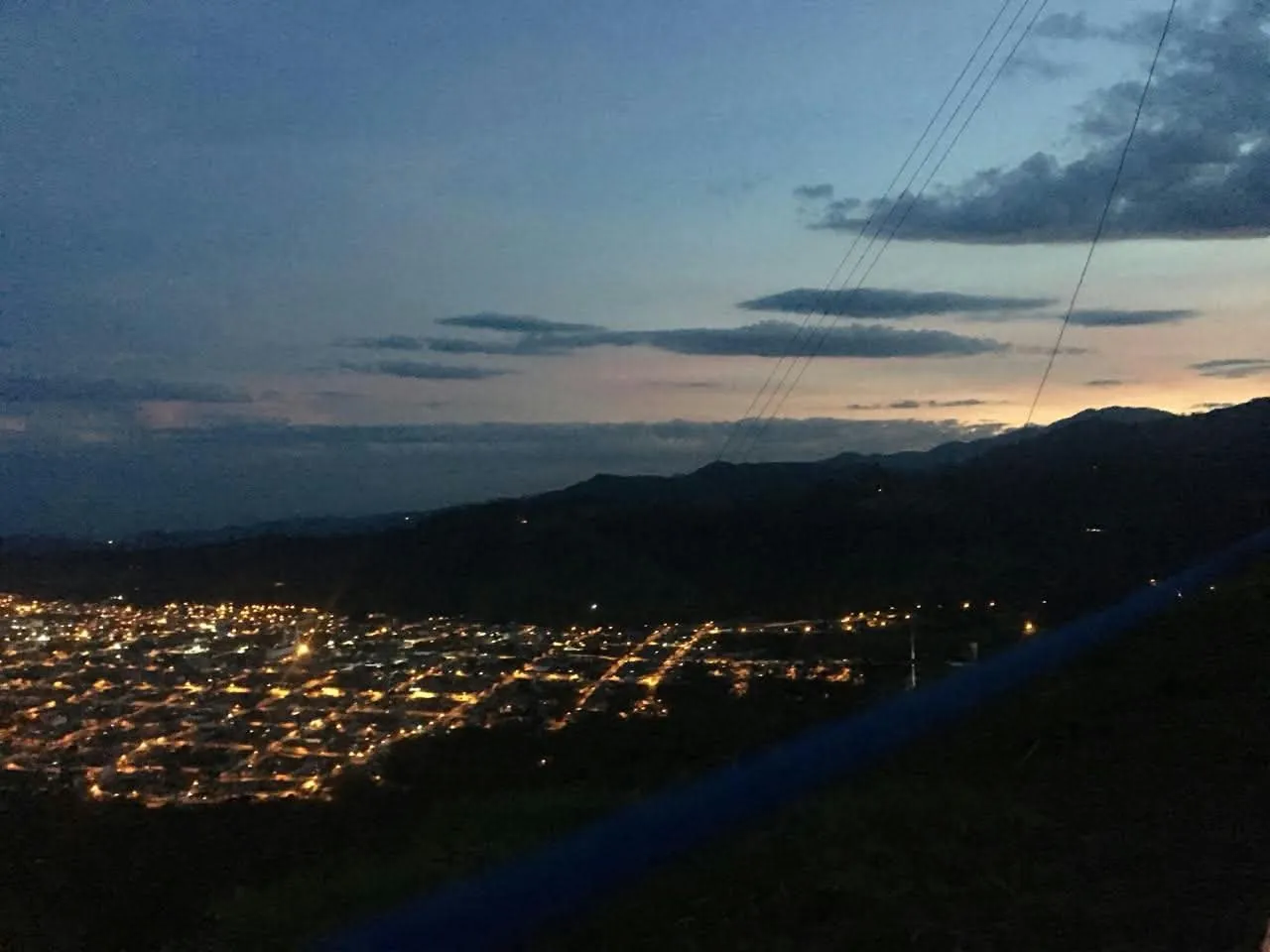 Luces de un pueblo de montaña al anochecer, vistas desde lo alto